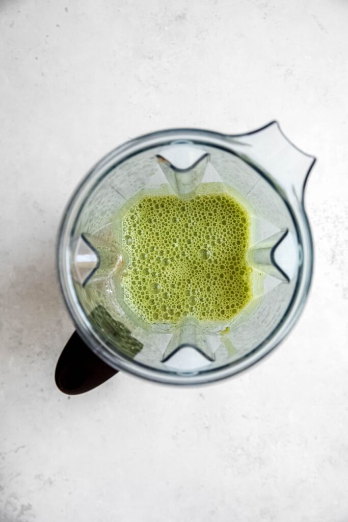 A blender with the blended spinach pancake base in it.