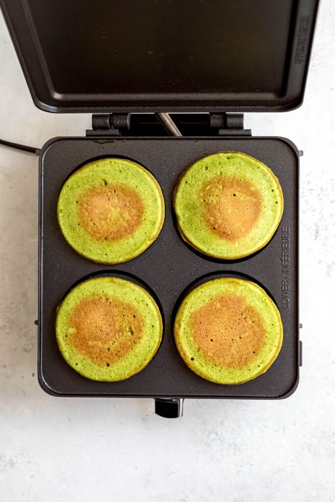 Cooked spinach pancakes in a pancake iron.