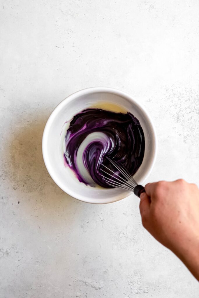 Whisking the ube pancake sauce in a small mixing bowl.