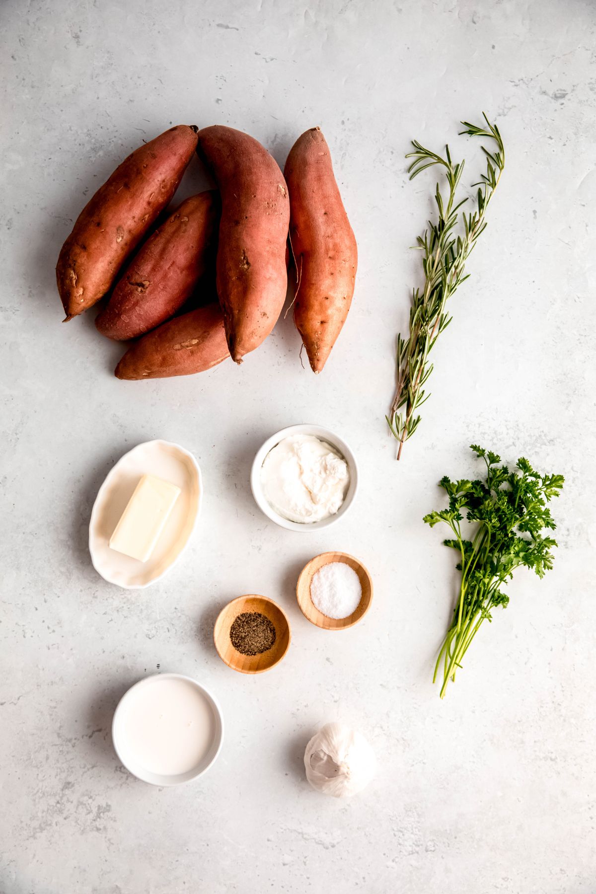 ingredients needed to make healthy mashed sweet potato recipe measured out on white table.
