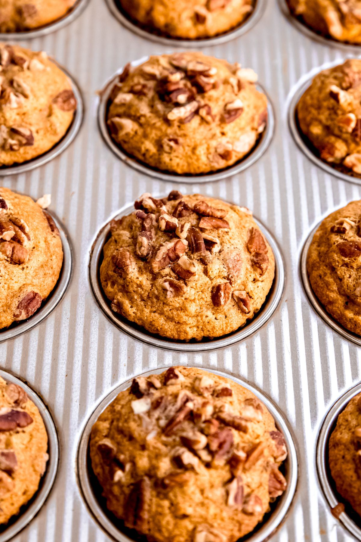closeup shot of healthy pecan muffins in a silver muffin tin.
