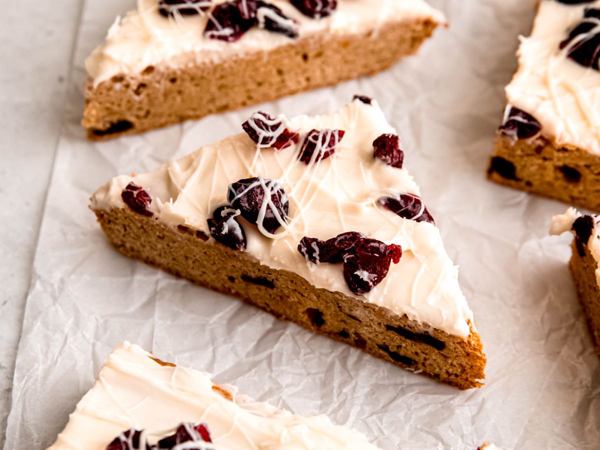 horizontally framed hero shot of DIY Starbucks cranberry bliss bars on a piece of white parchment paper.