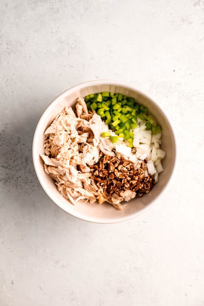 celery, onions, pecans, and shredded turkey added to the bowl with the creamy dressing.