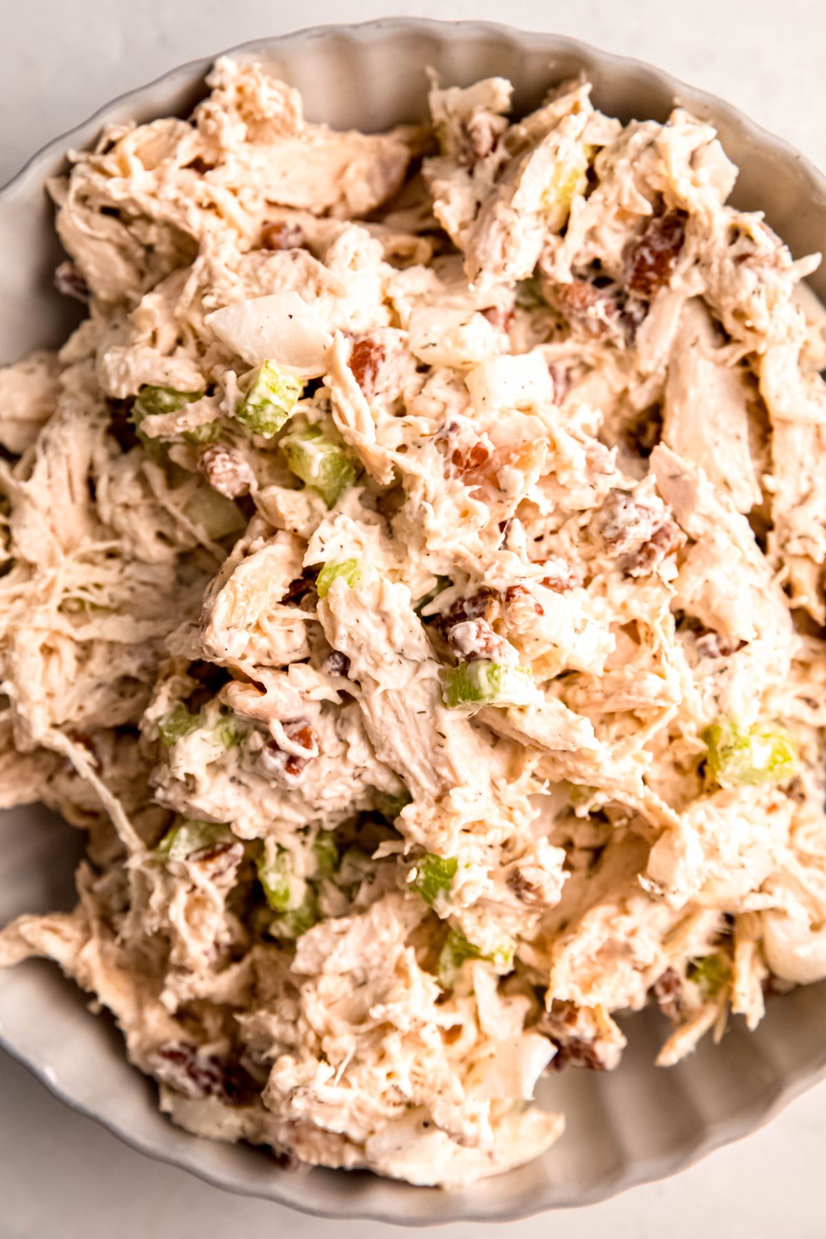 hyper closeup overhead shot of leftover turkey salad sandwich filling showing the shredded meat, creamy dressing, and crunchy mix ins.