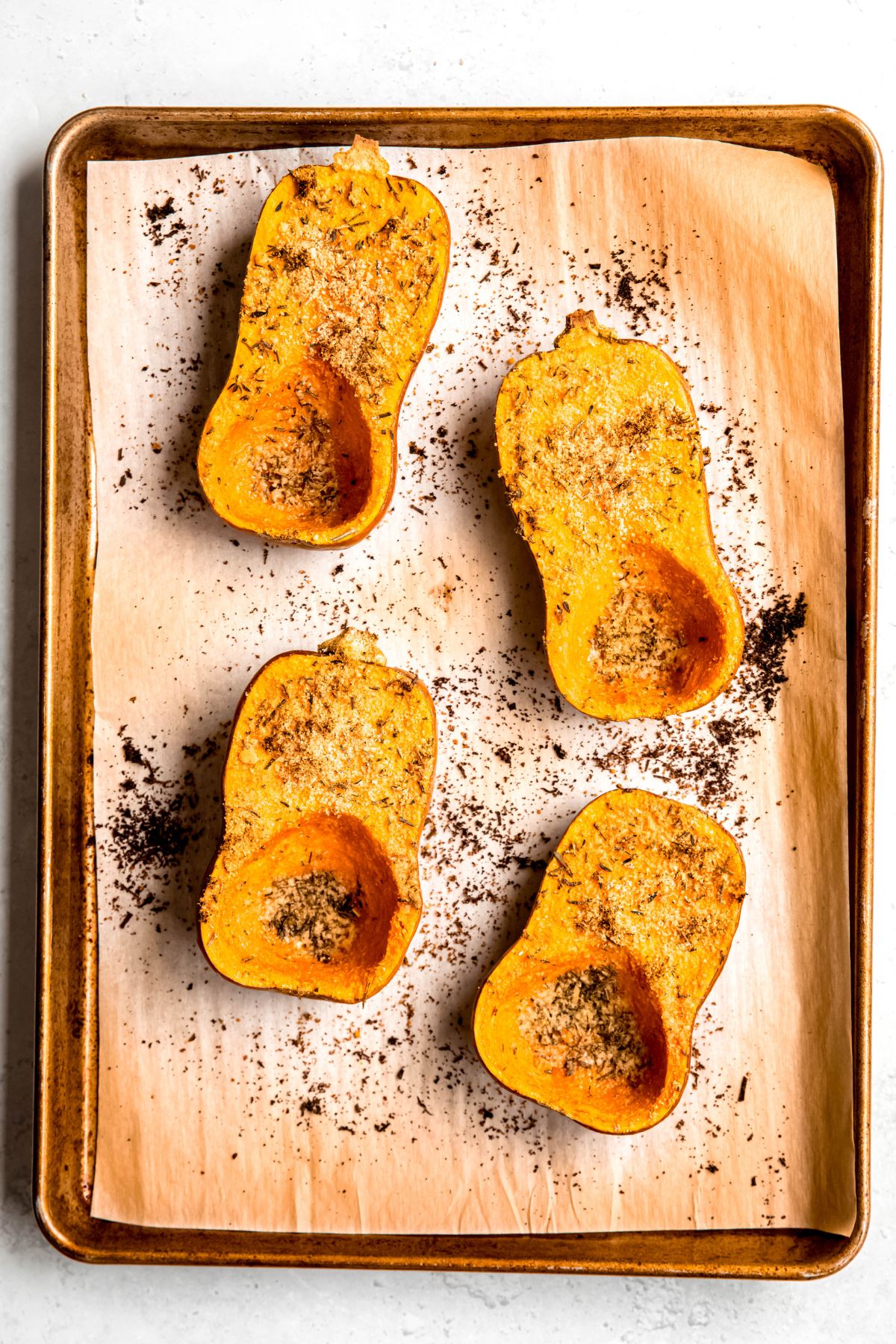 roasted honeynut squash on the parchment lined sheet after baking.