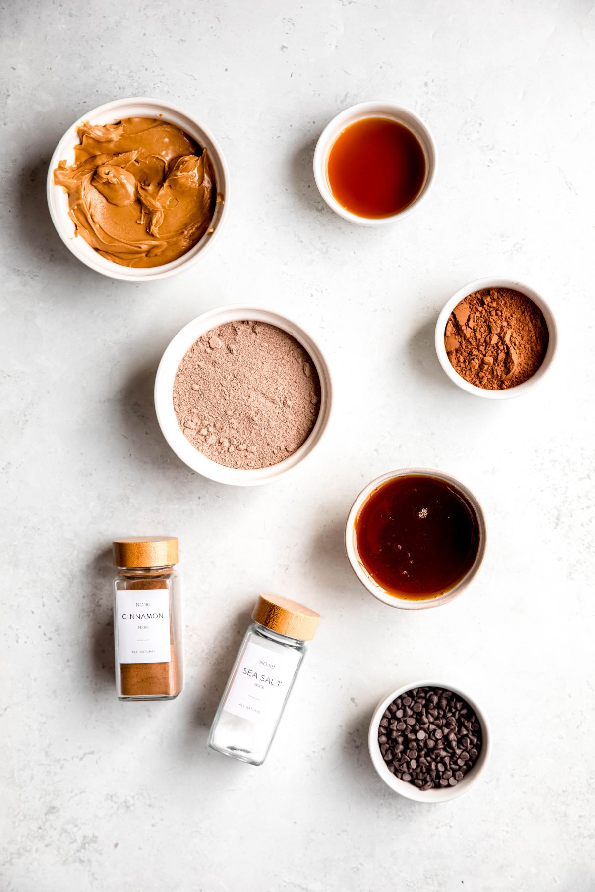 ingredients for making healthy homemade chocolate protein balls recipe measured out on a white table.