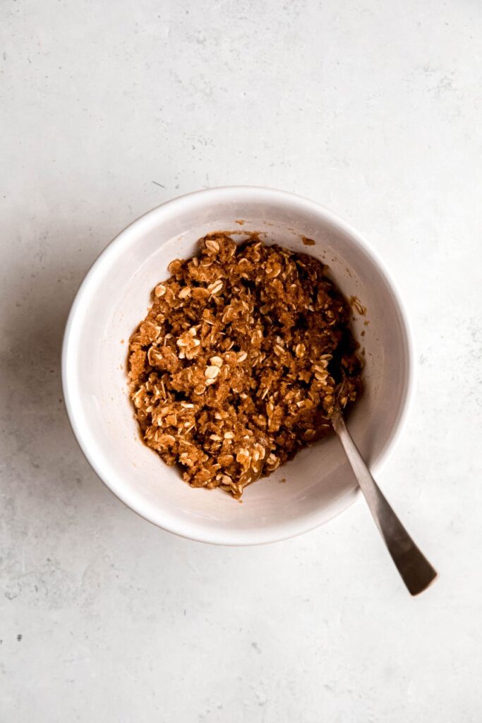 A small mixing bowl of the French toast casserole streusel opping.