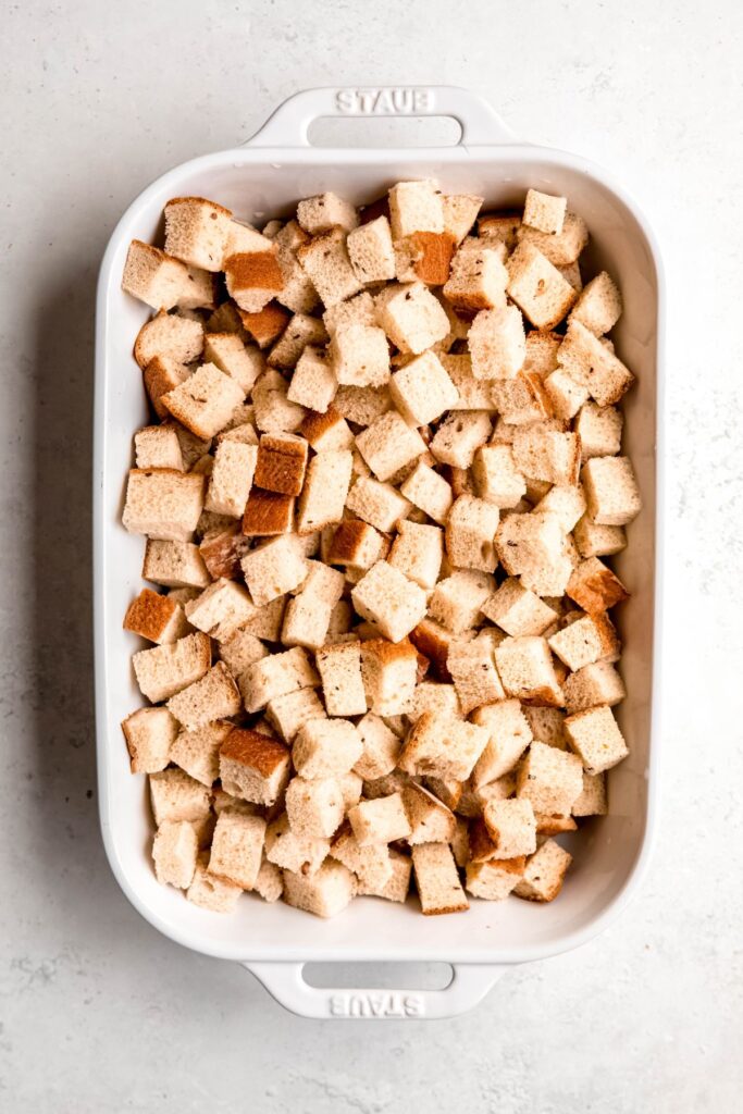 An overhead shot of a casserole pan of cubed bread.