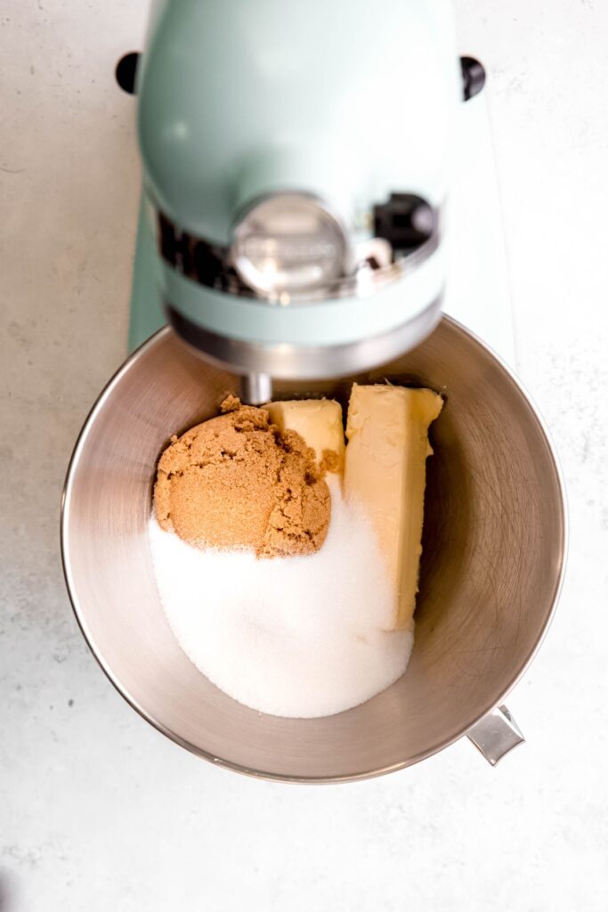 butter and sugars added to the metal bowl of a stand mixer.