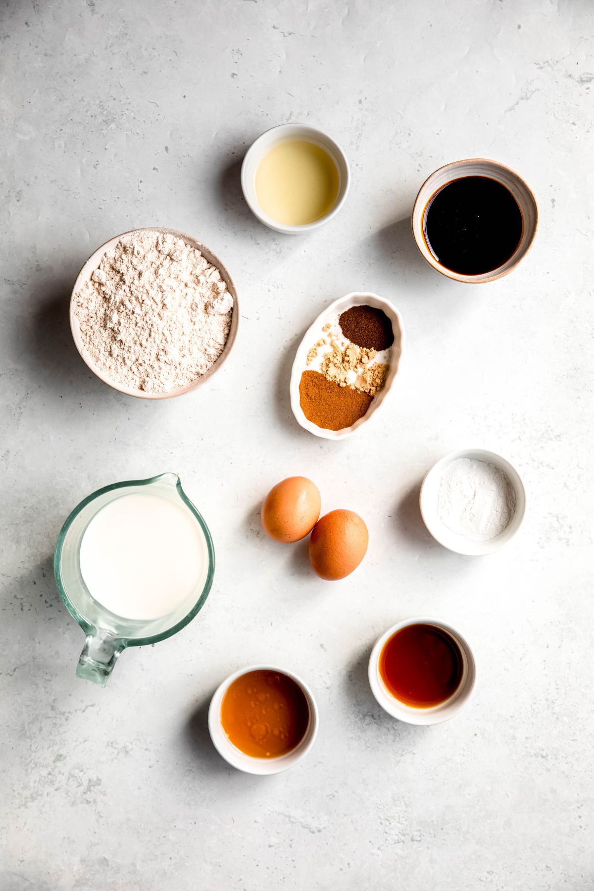 ingredients for making gingerbread pancakes recipe measured out on a white table.
