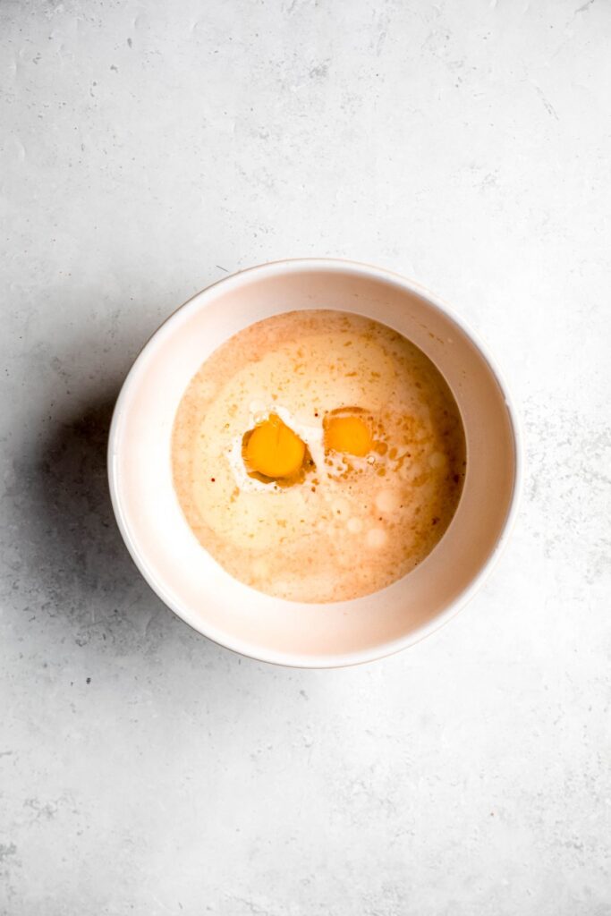 wet ingredients added to a white mixing bowl.