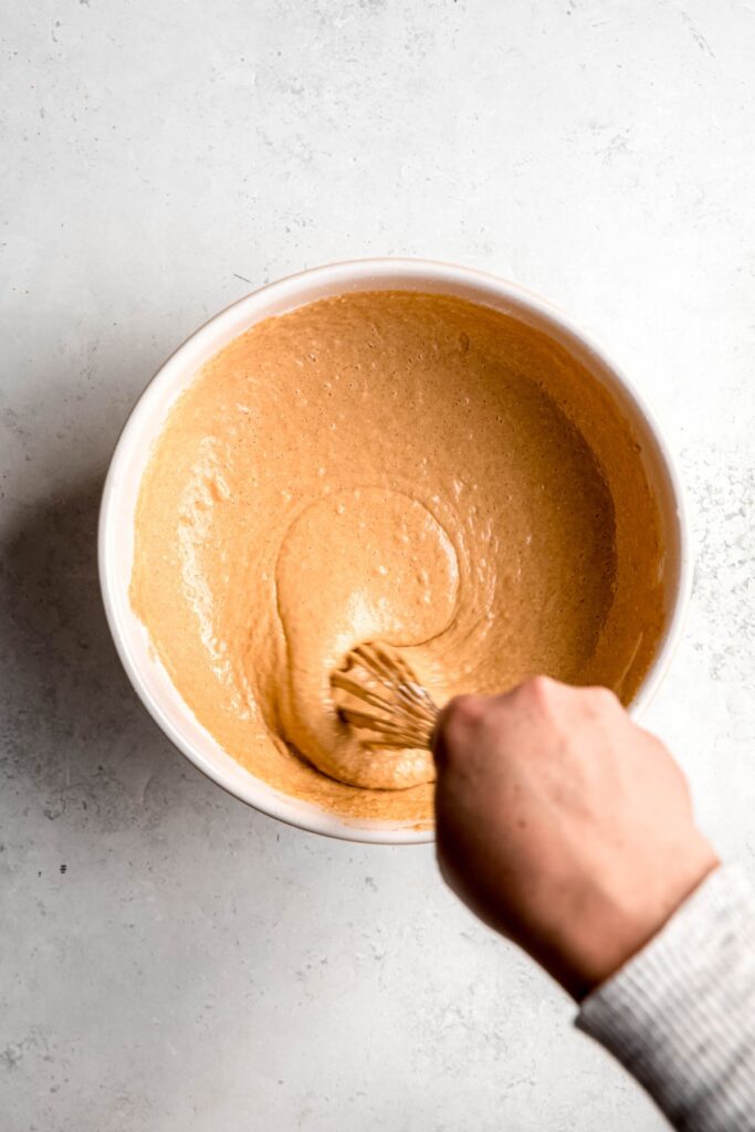active shot of a hand whisking the gingerbread pancake batter.