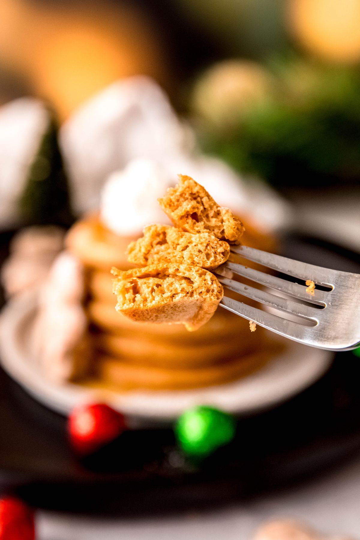 closeup shot of three pieces of a stack of gingerbread pancakes on a silver fork showing the fluffy interior.