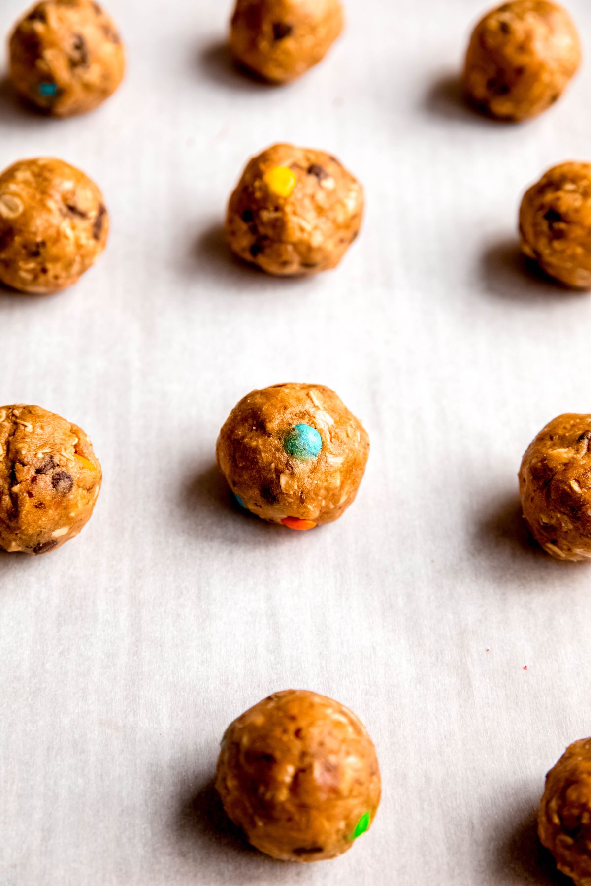 homemade monster protein balls on a parchment lined baking sheet.