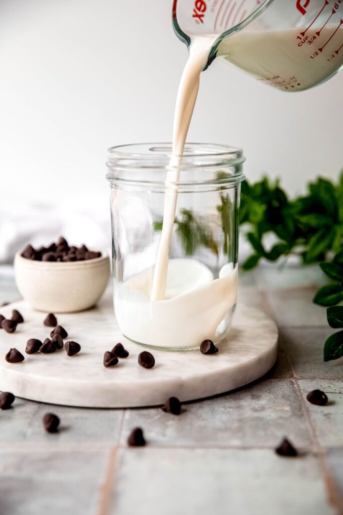 action shot of milk being poured in a mason jar.