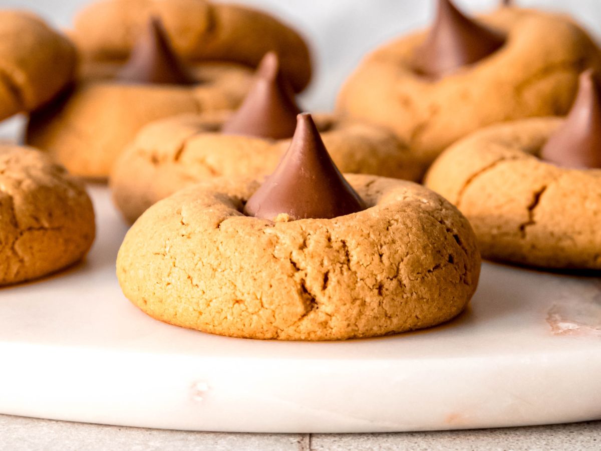 A horizontal shot of a close-up side shot of peanut butter protein blossom cookies on a tray.