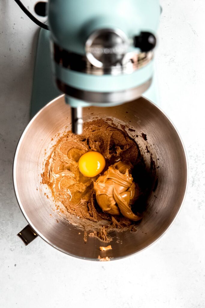 The peanut butter mixture in a stand blender with an egg.