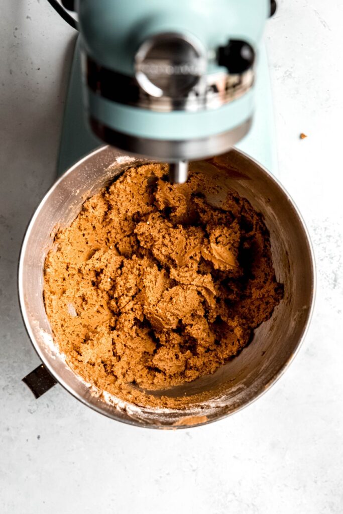 The peanut butter blossom mixture in the bowl of a stand mixture.