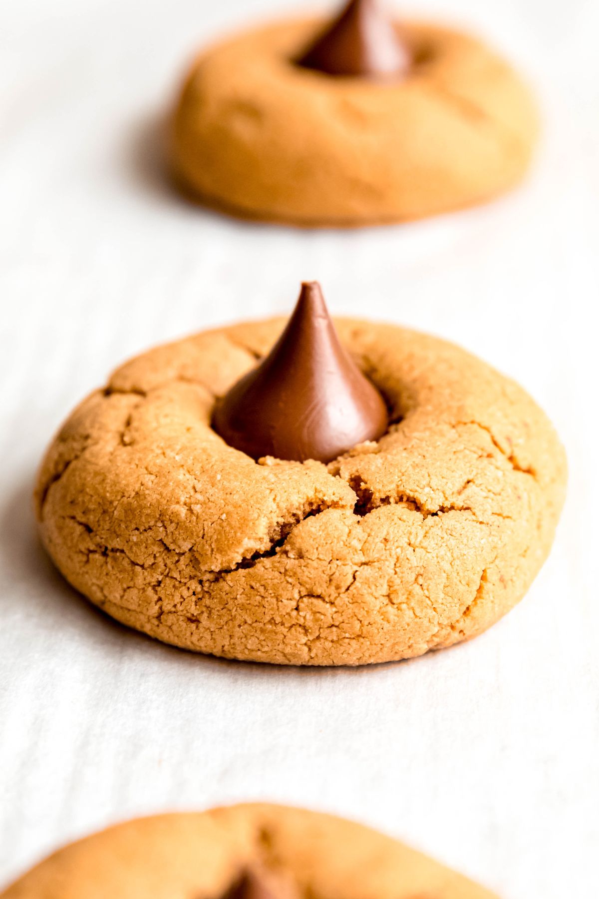 A close-up shot of a healthy peanut butter blossom on a baking tray.