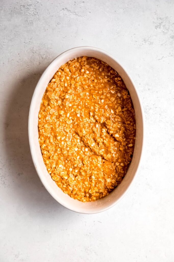 raw pumpkin oatmeal added to a casserole dish.
