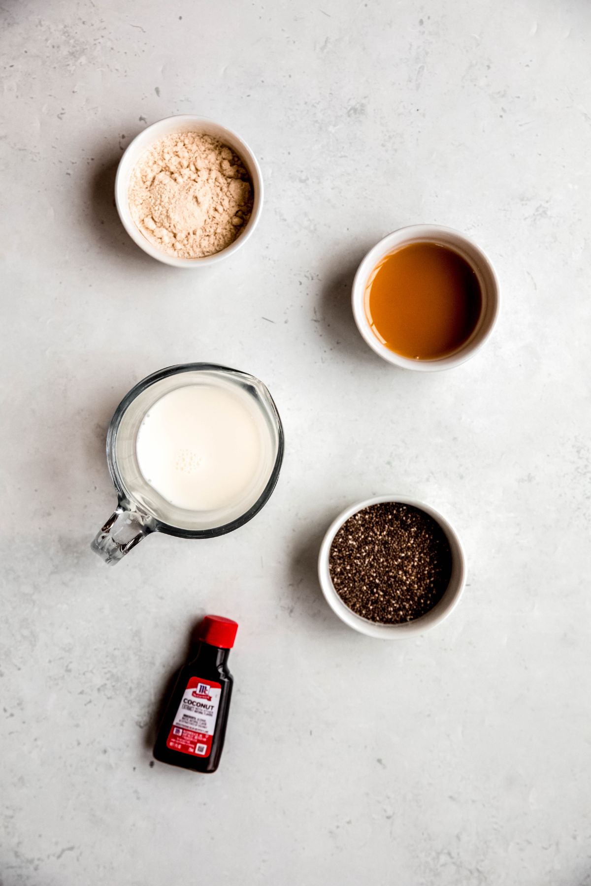 ingredients for making coconut chia seed protein pudding recipe measured out on a white table.