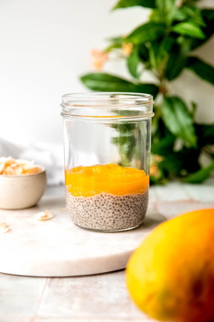 mason jar with a layer of coconut protein chia pudding and a layer of fresh mango puree.