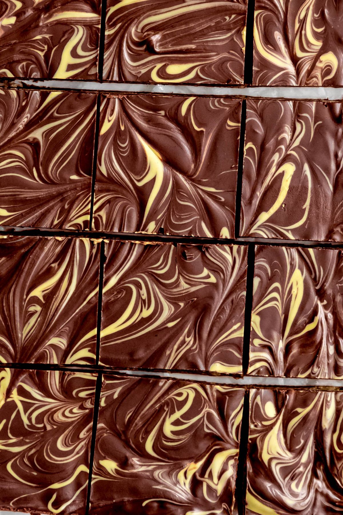 overhead shot of dubai chocolate brownies showing the beautifully swirled chocolate ganache and pistachio cream topping.