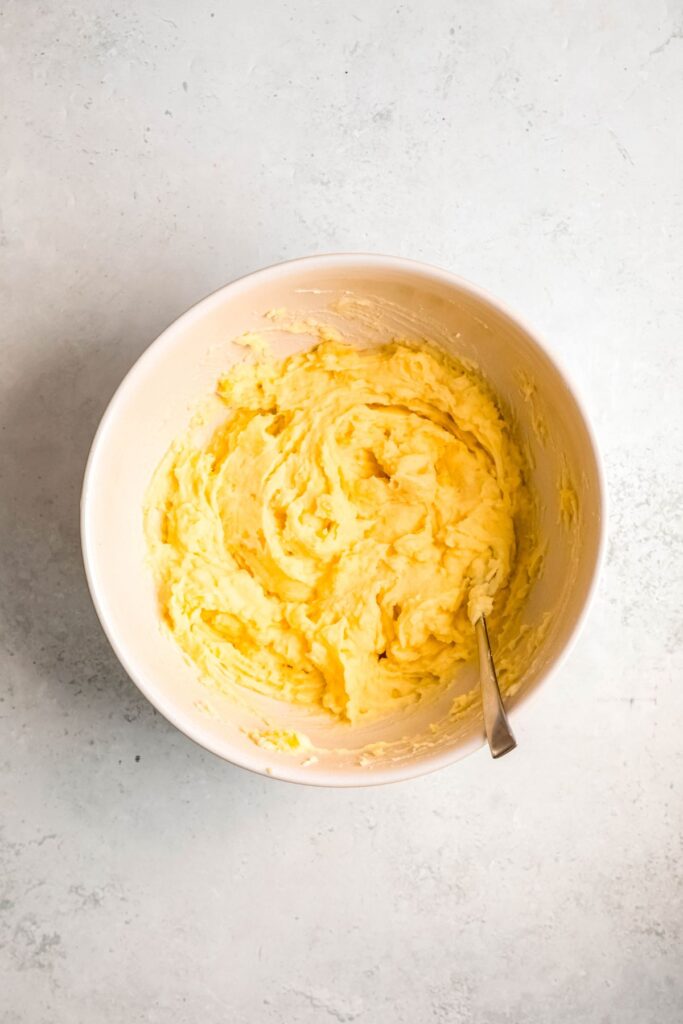 An overhead shot of the mashed potatoes in a large bowl with a spoon.
