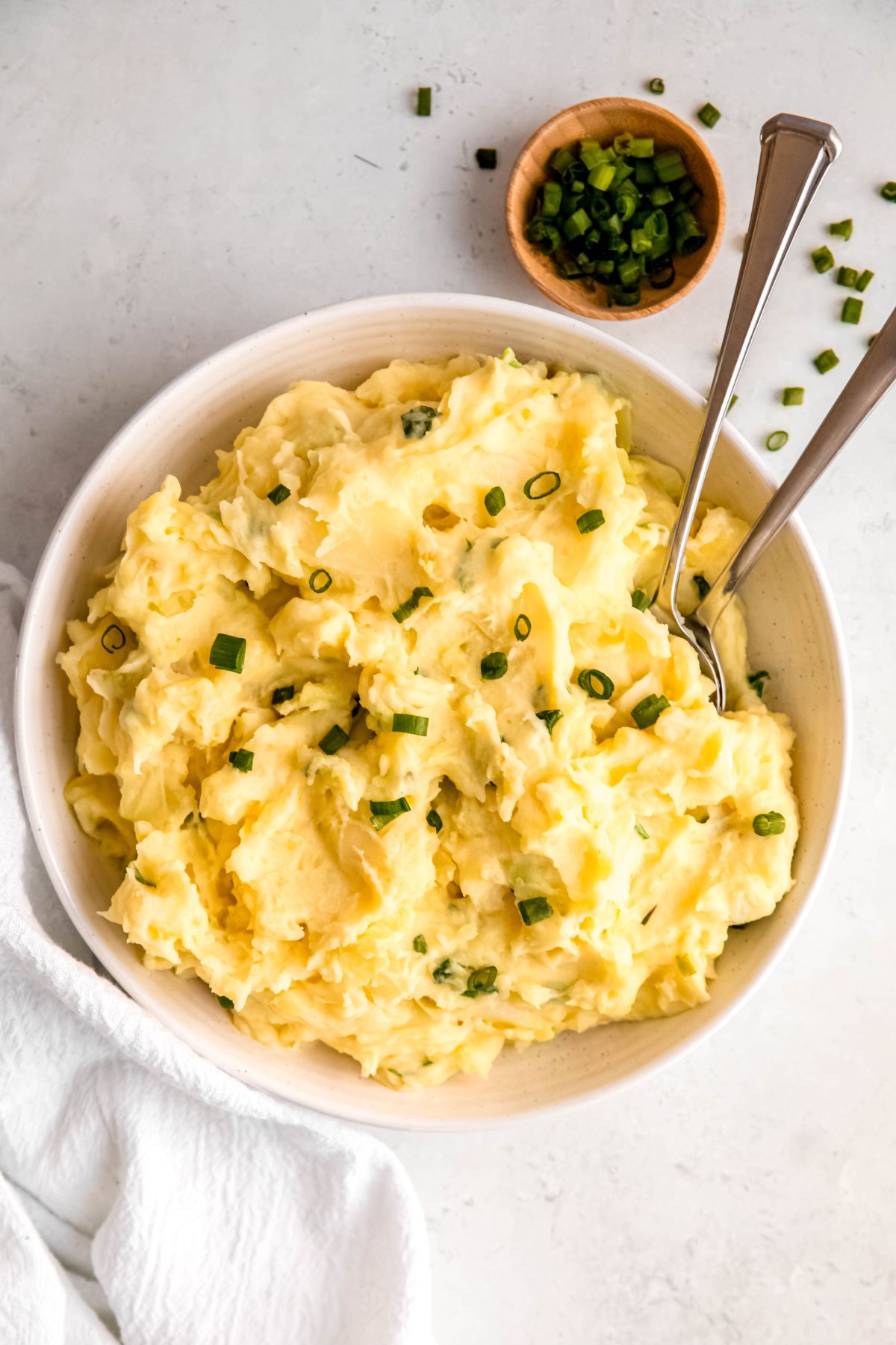 An overhead shot of a serving bowl of Irish mashed potatoes with two large spoons.