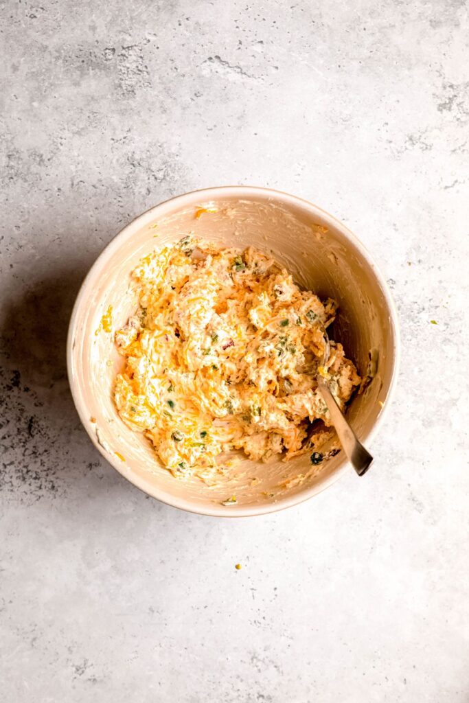jalapeno popper dip mixture in the mixing bowl after folding in the cheese, peppers, and bacon.