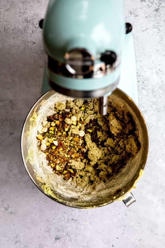 pistachios and white chocolate chips added to the bowl with the cookie dough.