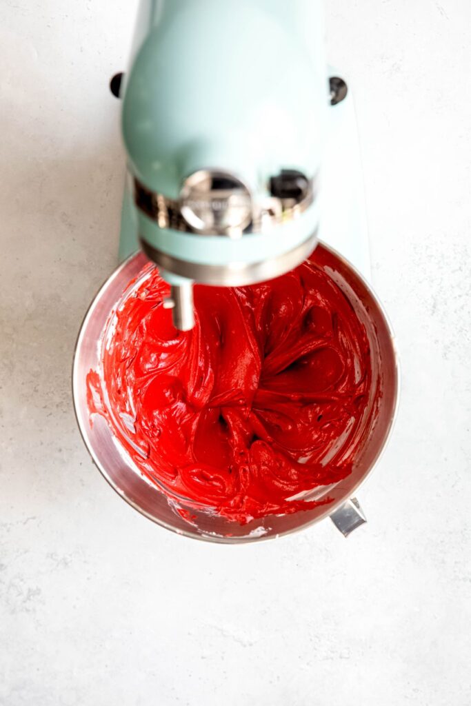 red velvet cheesecake swirl mixture in the base of a stand mixer after beating.