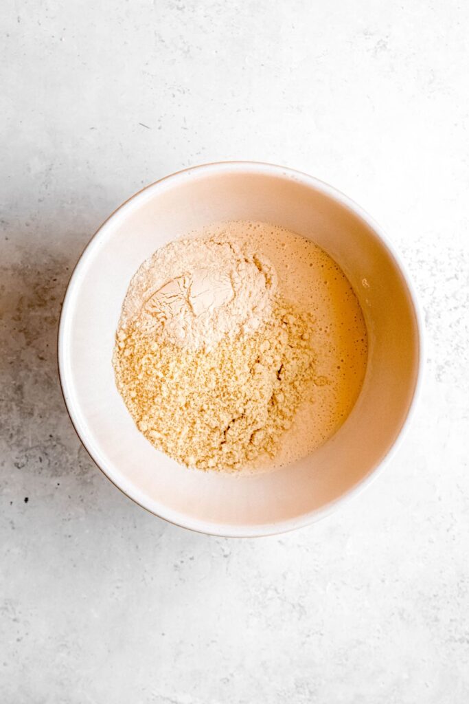 protein powder and almond flour added to a bowl with the blended cottage cheese mixture.