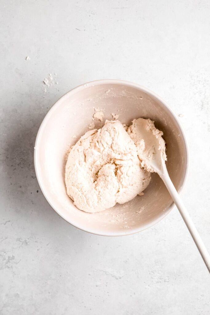 cottage cheese flatbread dough in a mixing bowl after adding self rising flour.