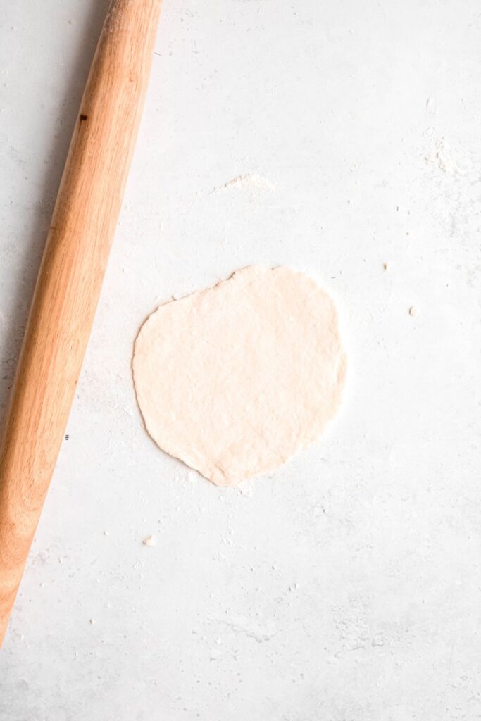 flatbread dough disc after rolling one piece out.
