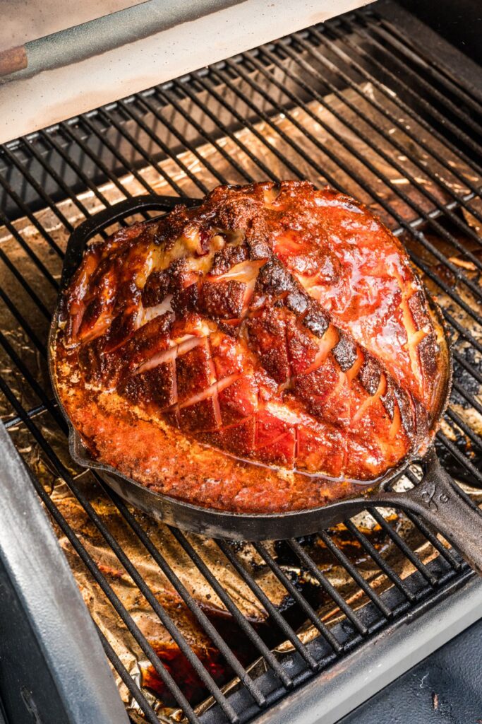 finished double smoked ham in the cast iron pan in the smoker after cooking the glaze until sticky and golden.