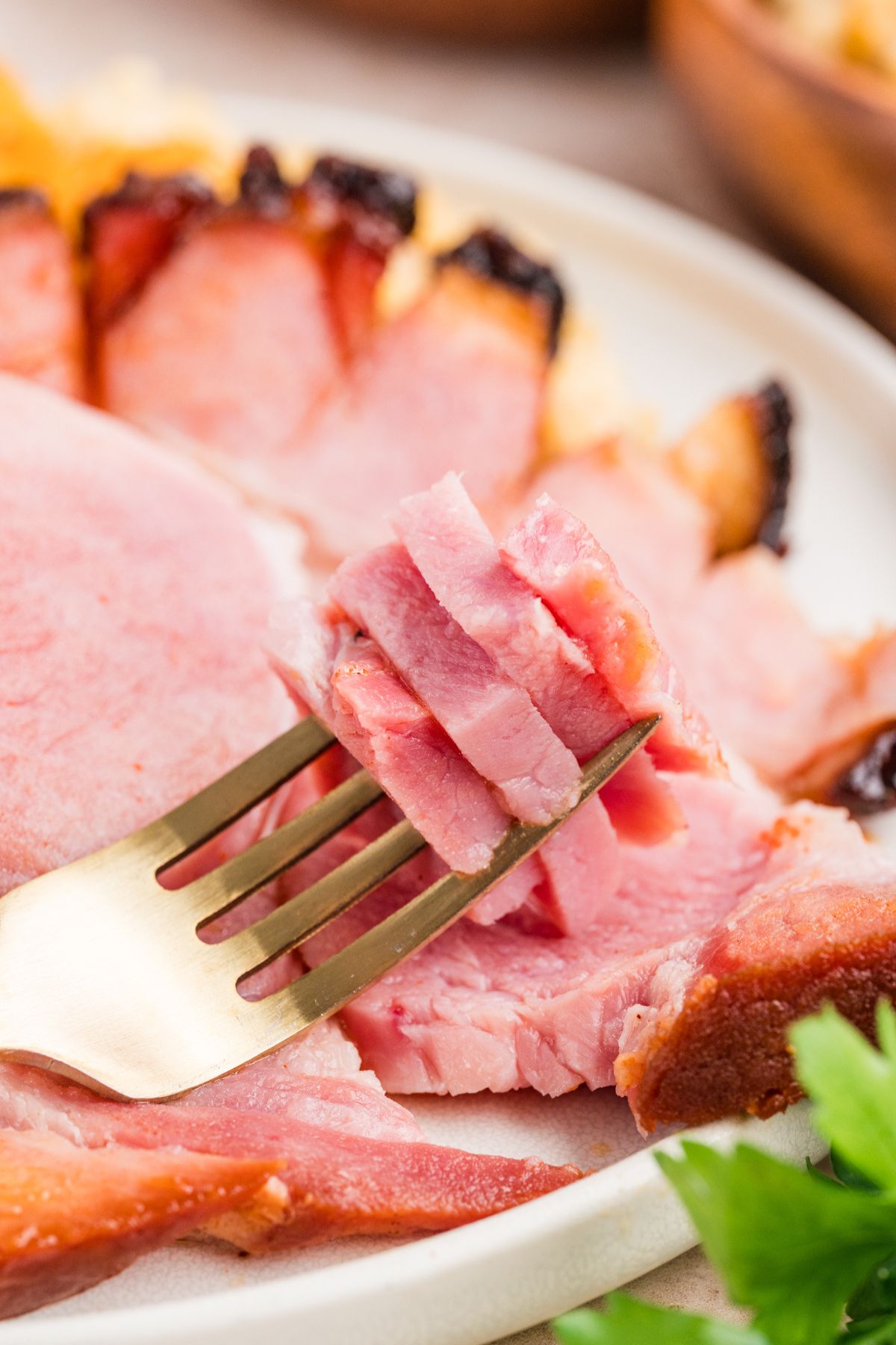 closeup shot of a forkful of double smoked ham showing how juicy the meat is.