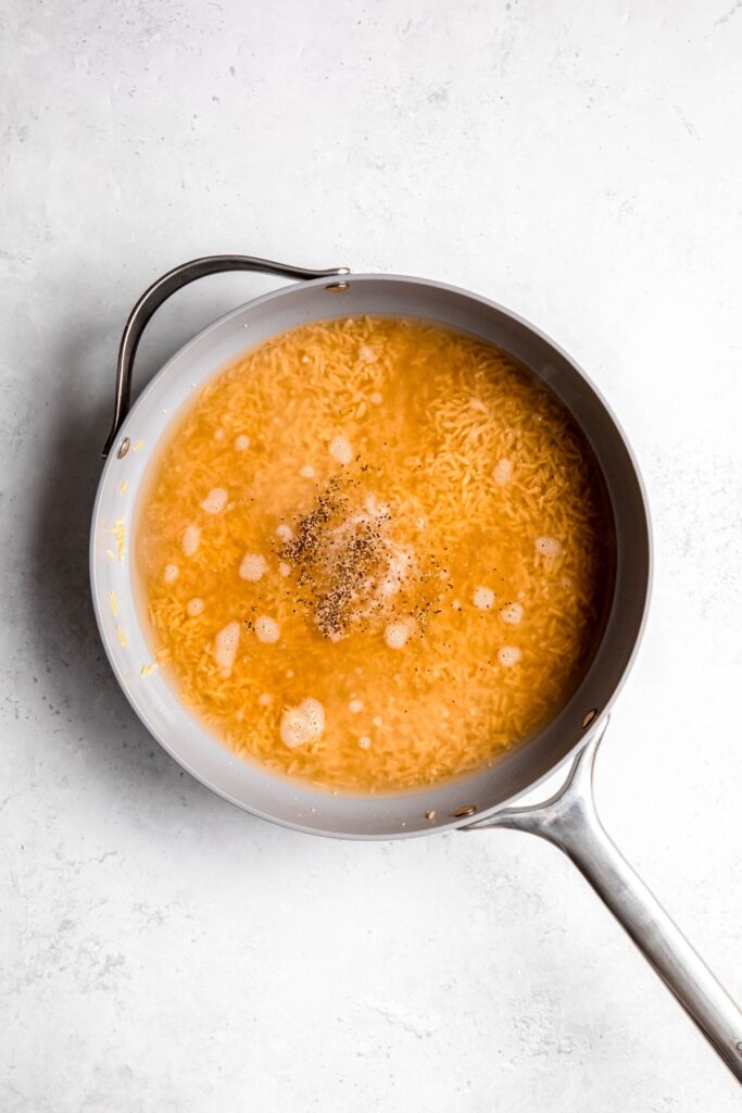 broth added to the toasted orzo to simmer and cook.