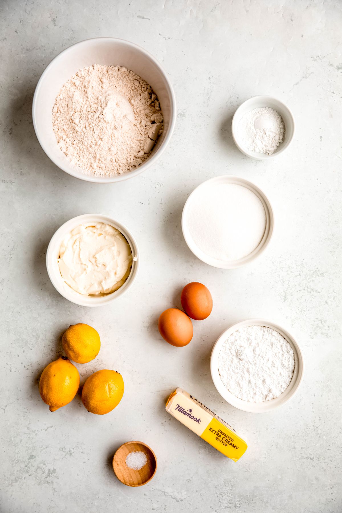 ingredients needed to make lemon ricotta cookies recipe measured out on a white table.