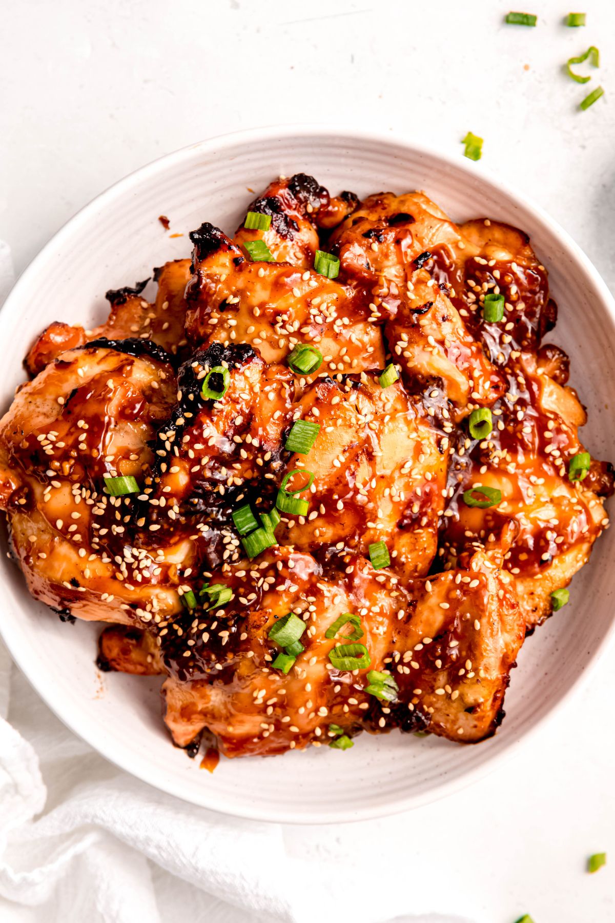 serving platter of grilled chicken teriyaki thighs after tossing with leftover sauce.