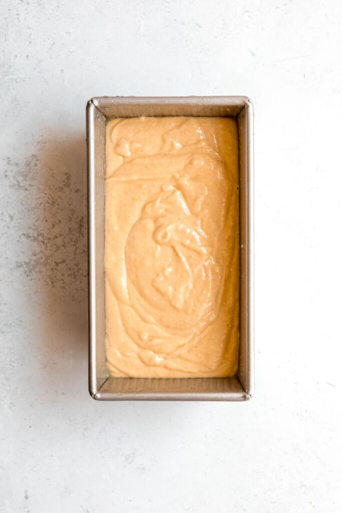 lemon loaf cake batter poured into a prepared pan.