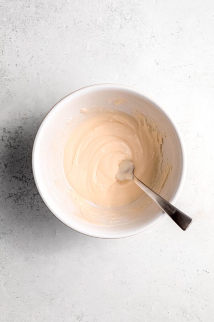 lemon glaze ingredients whisked together in a mixing bowl.