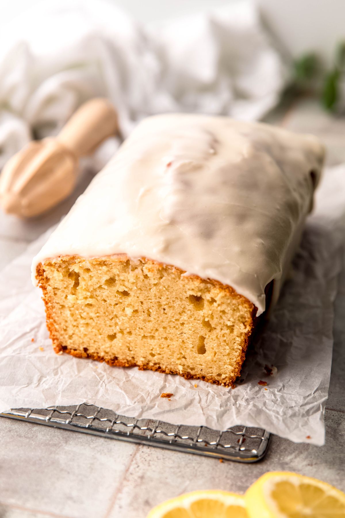 homemade Starbucks lemon pound cake loaf with a slice taken out revealing the airy, tender crumb inside and showing the thick white lemon icing on top.