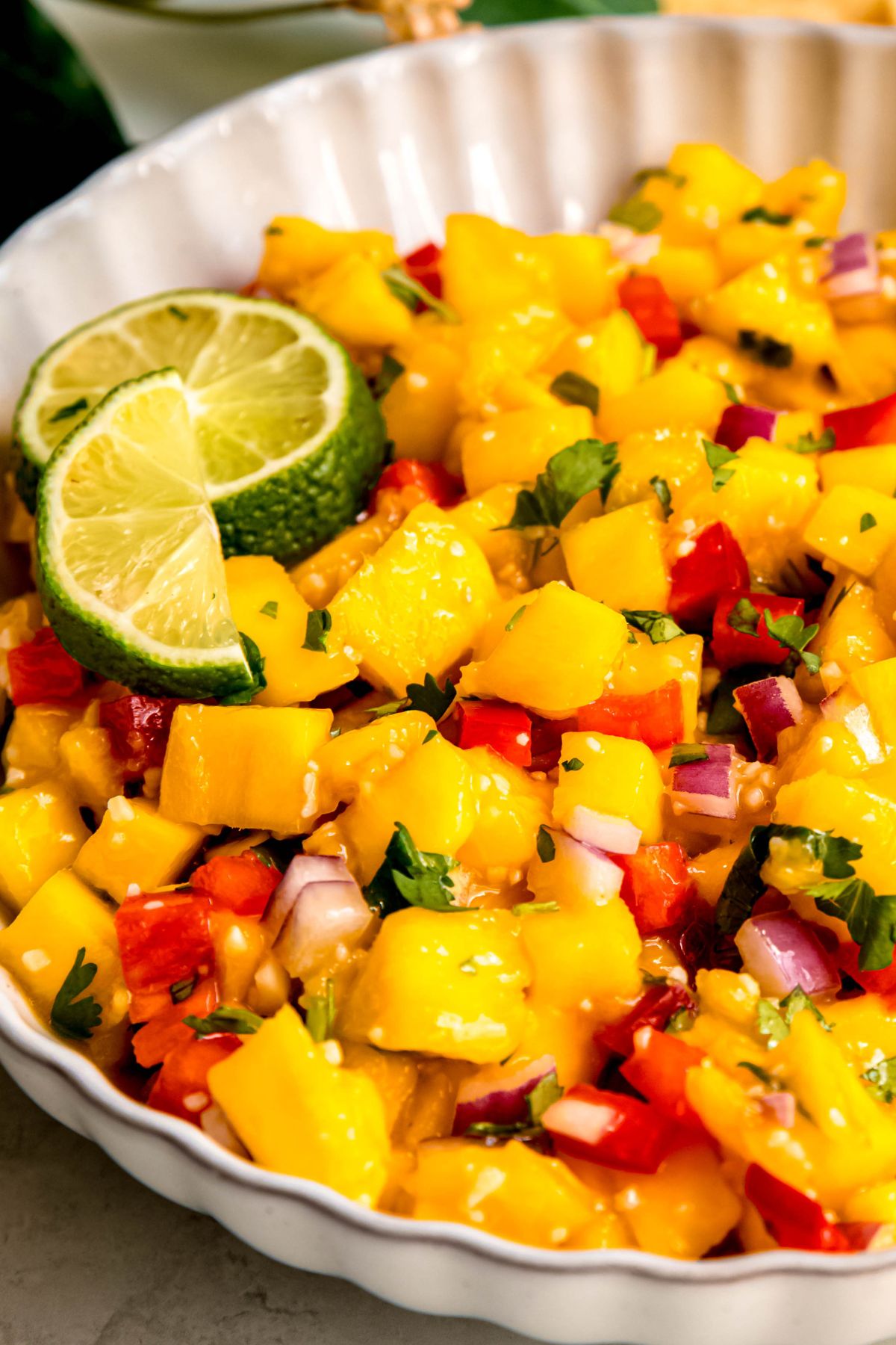 closeup shot of mango jalapeno salsa in a serving bowl showing all the vibrant colors of the produce.