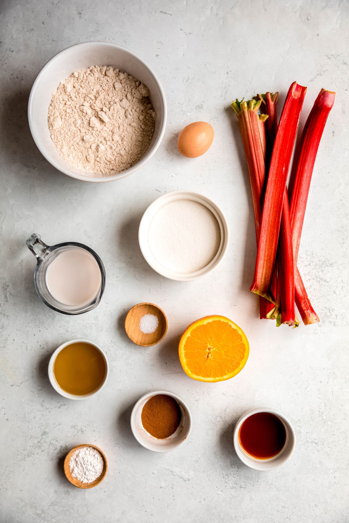 ingredients needed to make whole wheat rhubarb bread recipe measured out on a white table.