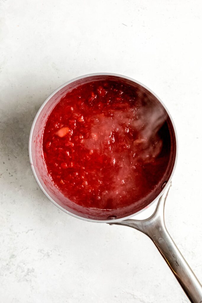 chunky rhubarb sauce ingredients simmering in a saucepan.
