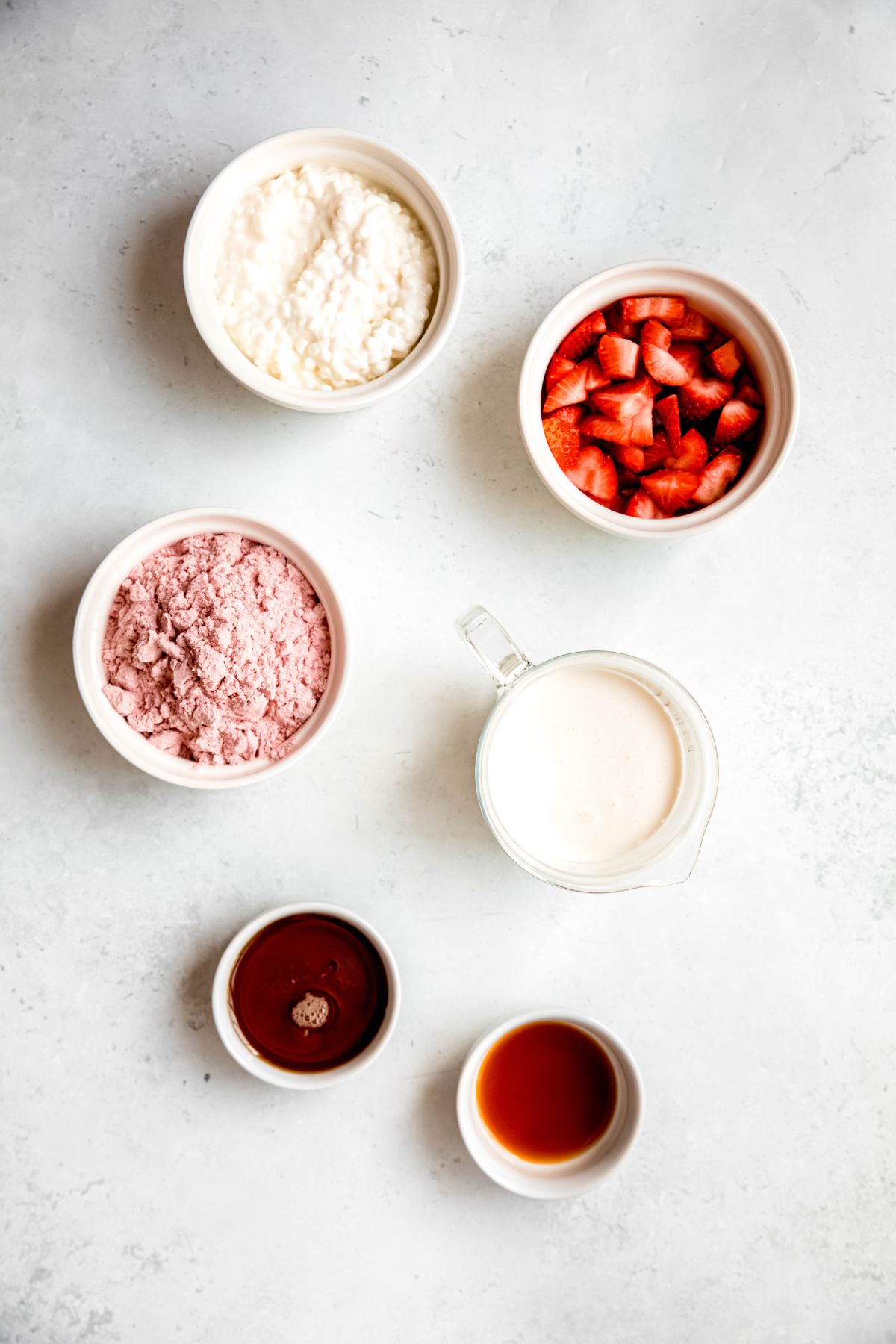 ingredients needed to make high protein strawberry fluff mousse measured out on a white table.